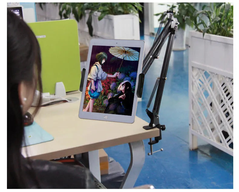 Black adjustable phone and tablet stand on a desk, measuring 10cm in height.