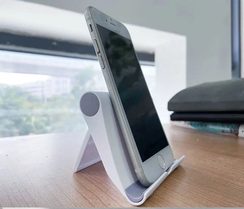 Black PE folding mobile phone stand holding tablet at 45-degree angle on wooden desk