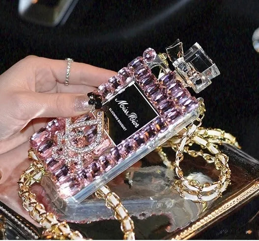A matte silicone iPhone case with a perfume bottle bow design and a detached metal chain strap.