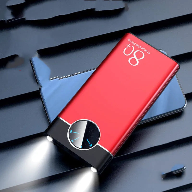 Black fast charging 20000mAh power bank with alloy shell and LED flashlight on a table.