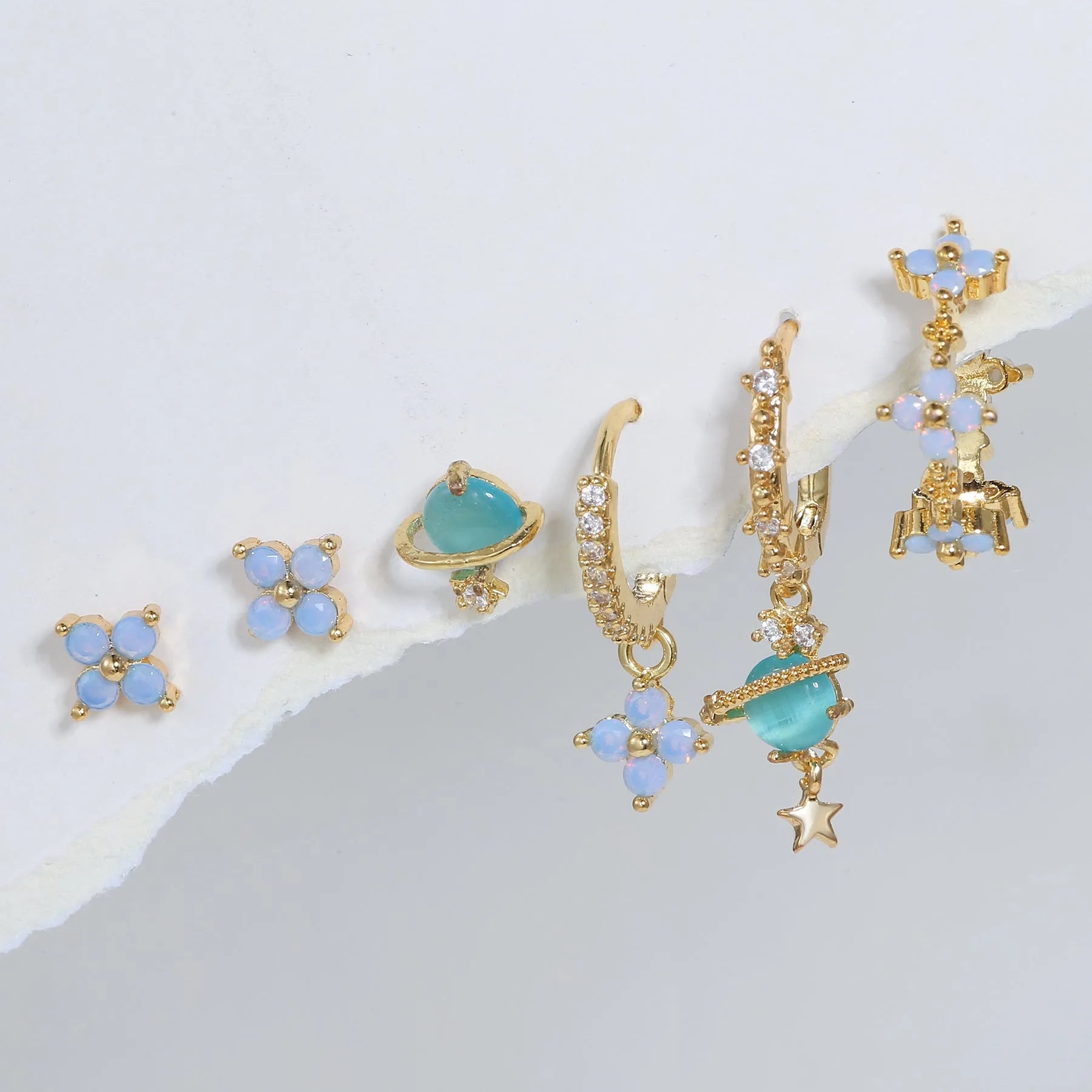 Flower-shaped ear studs with zircon mosaic in gold or silver finish, showing geometric design details