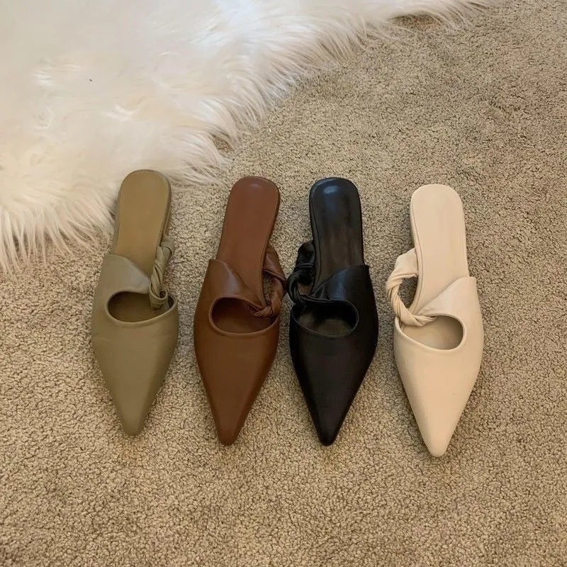 Women's soft leather semi-toe box slippers in black with a rubber sole, shown from the side.