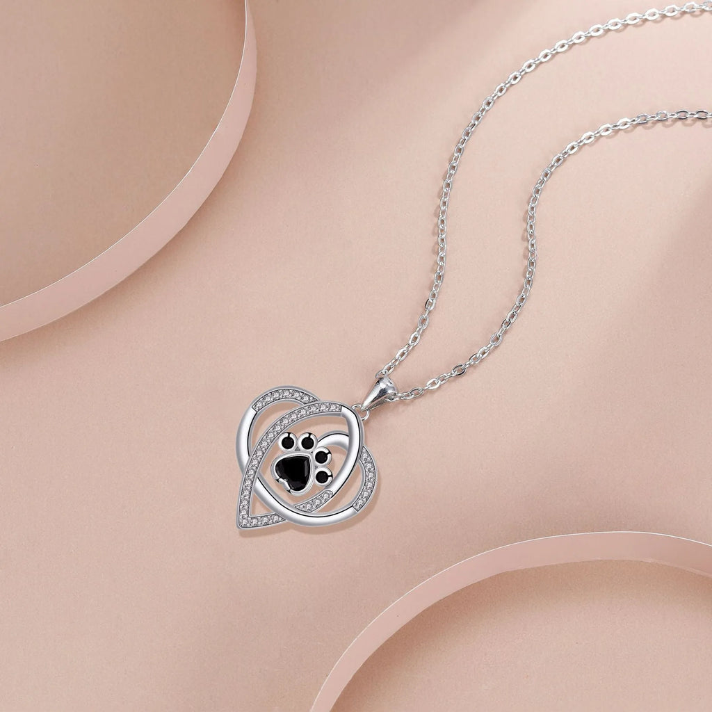 Copper pendant necklace showing cat and dog paw prints on a delicate cross chain.