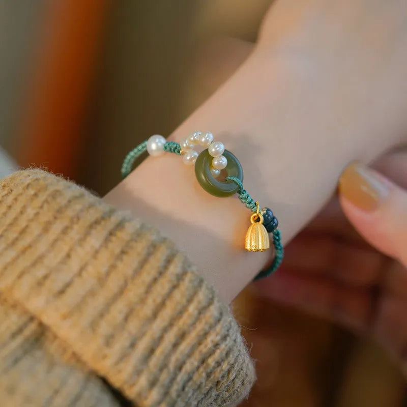 Close-up of a hand-woven flexible wire watch band with a pearl peace buckle closure.