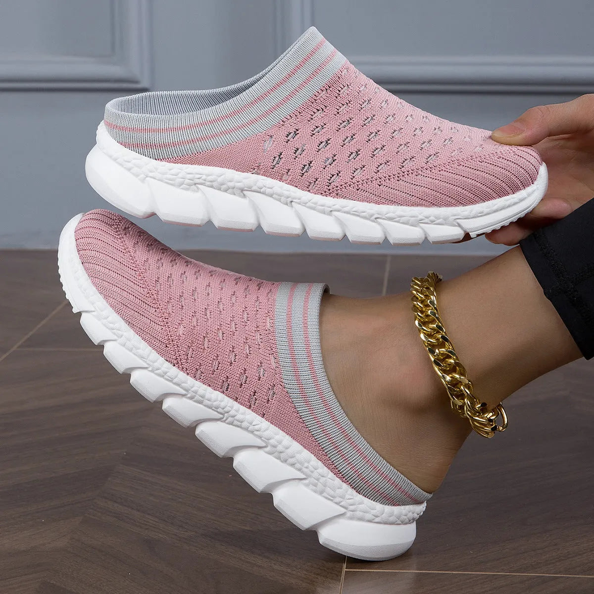 Women's black Flyknit slipper shoes with striped pattern and hollowed-out design on a white background.