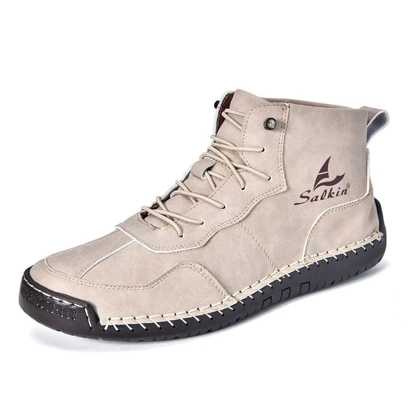 A pair of beige retro high-top casual leather boots with a round toe and elastic band fastening on a plain background.