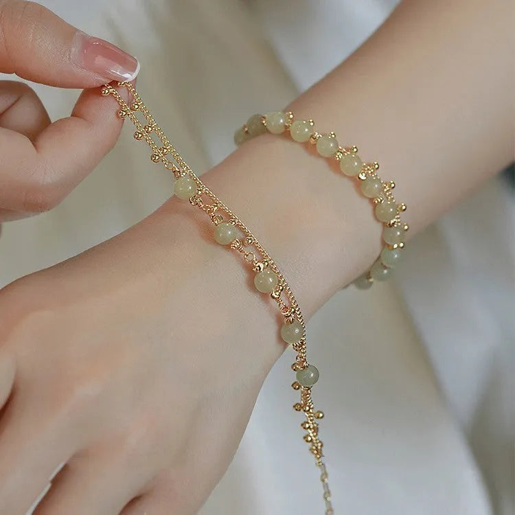 Natural Hetian Jade beaded bracelet with princess running motif on a wrist.