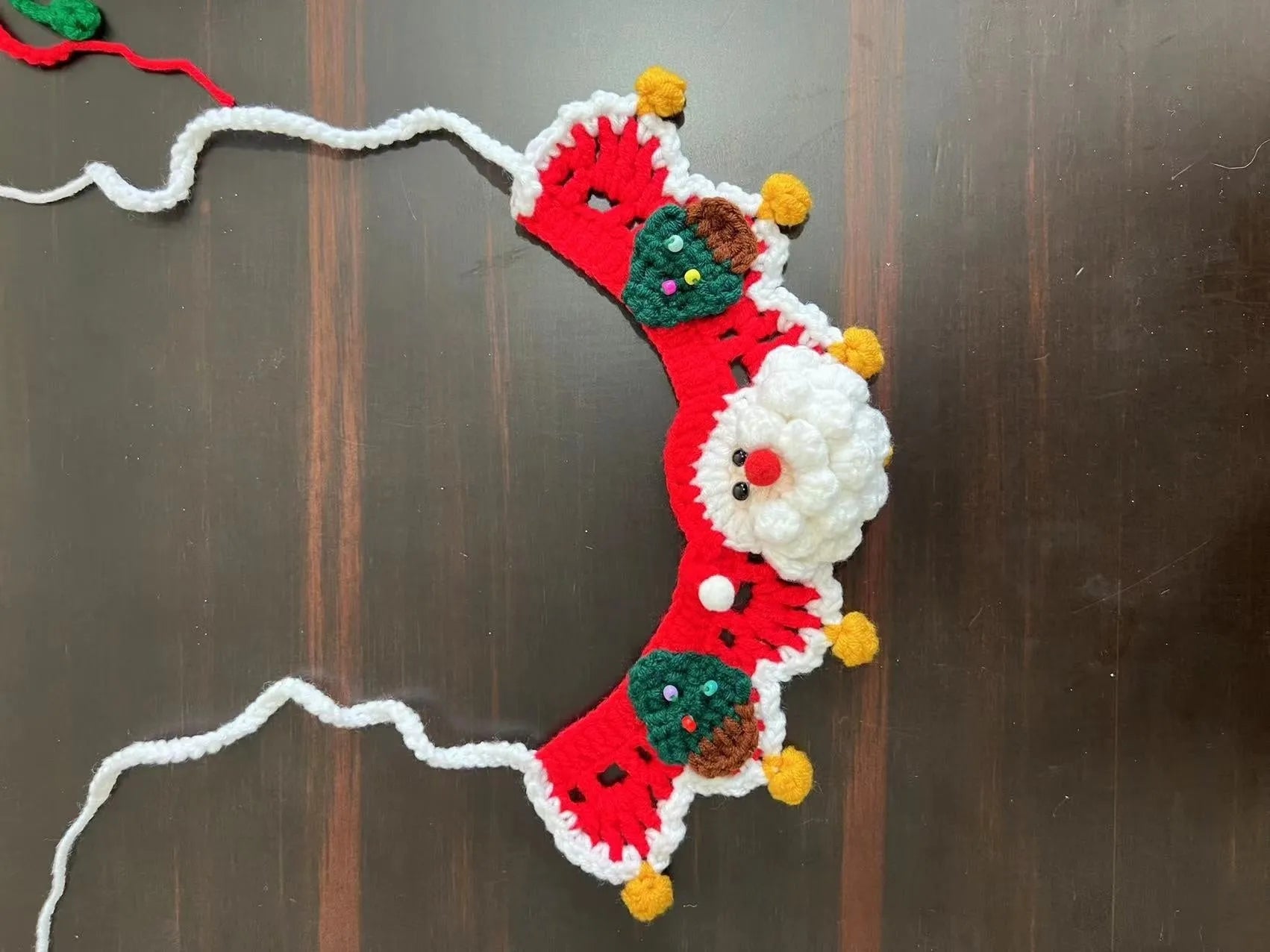Knitted wool Christmas scarf for a small dog featuring a striped Santa Claus pattern.