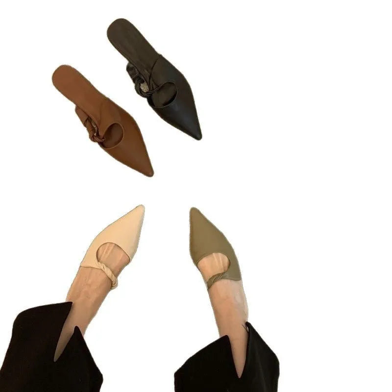 Women's soft leather semi-toe box slippers in black with a rubber sole, shown from the side.