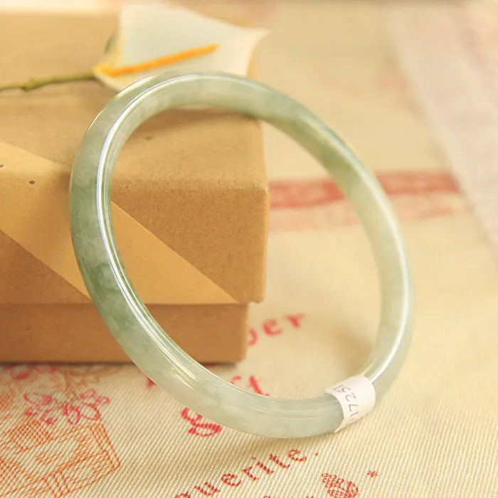 Green jade waxy geometric bracelet with Chinese design elements on wrist