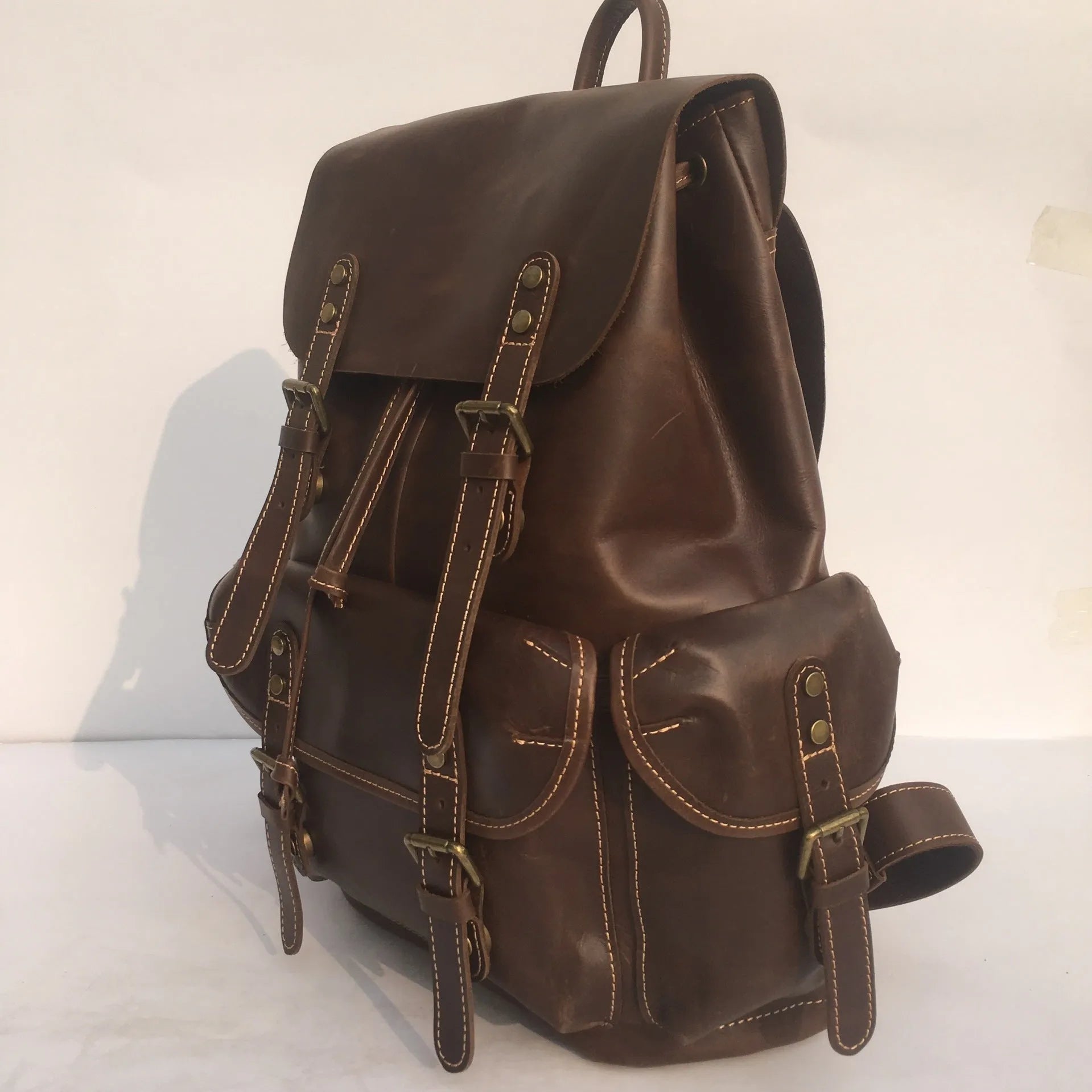 Brown men's genuine cowhide leather backpack with air pillow belt straps.