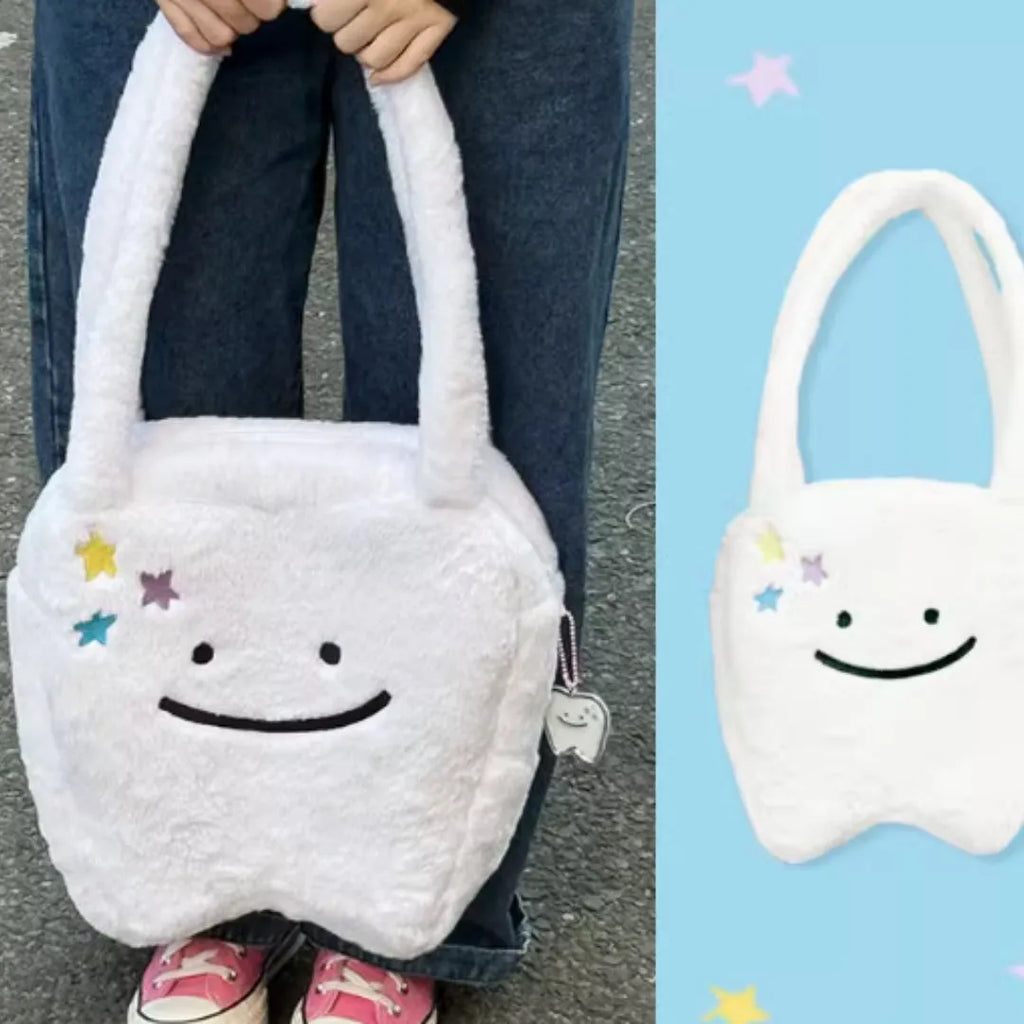 White plush tote bag with cute tooth graphic and a crossbody strap.