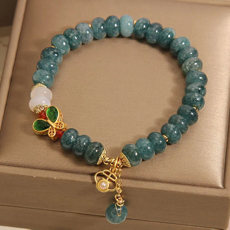Women's blue water jade abacus bead crystal bracelet with butterfly charm and white agate accents