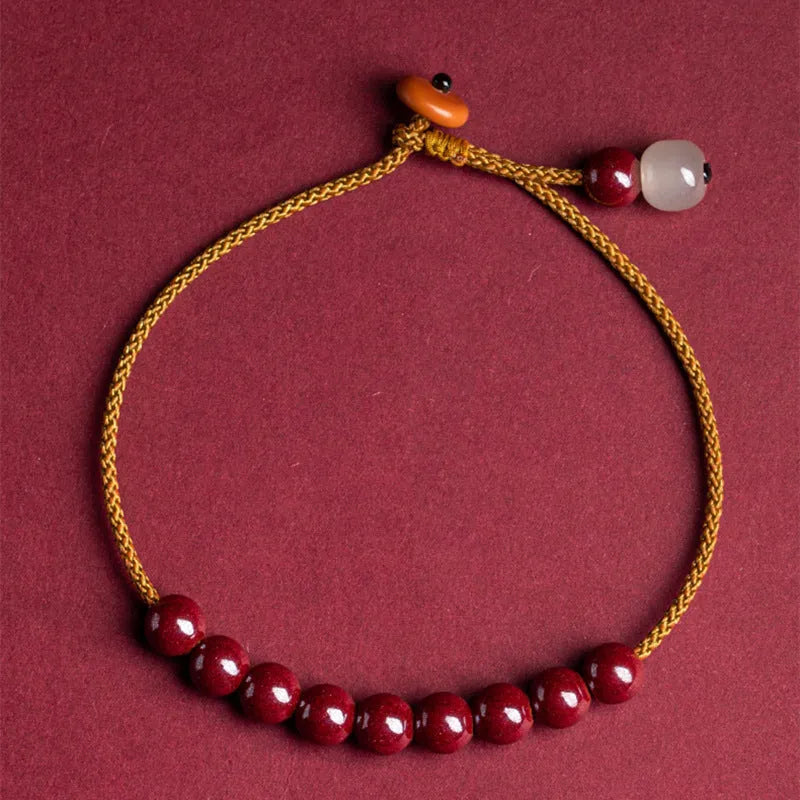 Hand-woven bracelet made from raw cinnabar and Hetian jade beads in a geometric design.