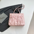 Black PU leather bow tote bag with double shoulder straps, shown with interior zipped pocket.