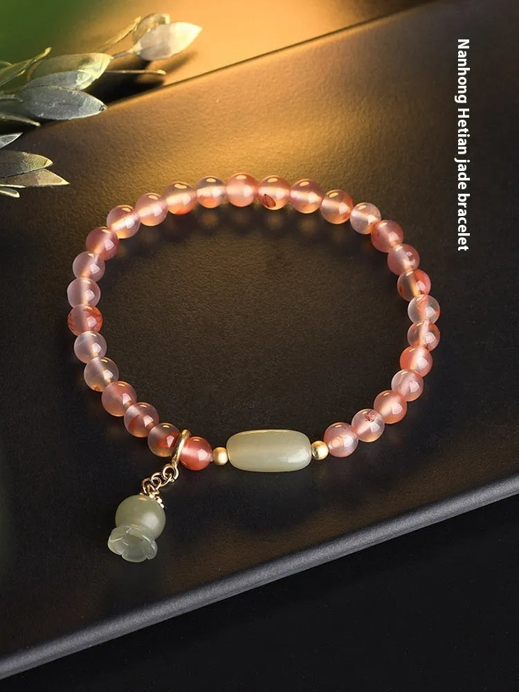 Close-up of a handmade nanhong agate bracelet with a flower design and bamboo joint detail.