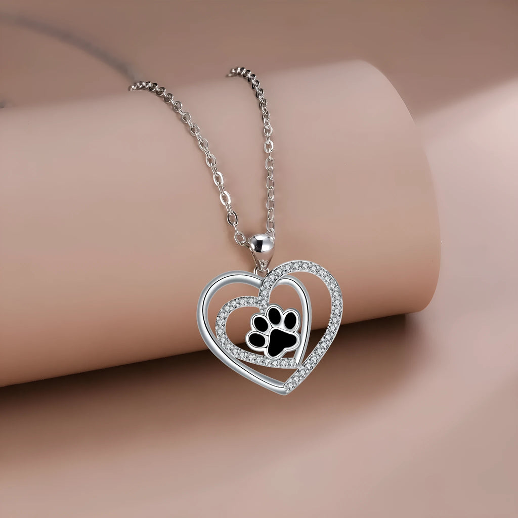 Women's copper necklace with dog paw and heart pendant on a cross chain.