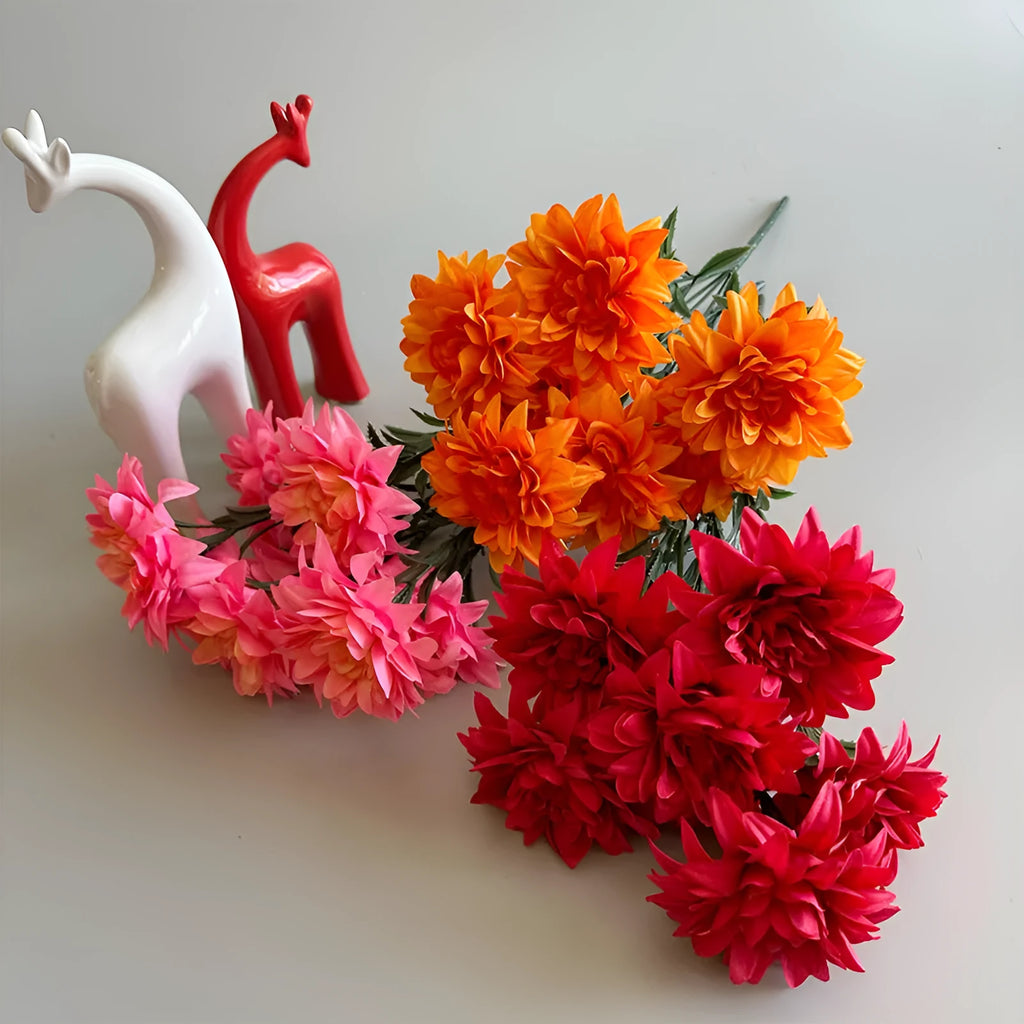 A fan-shaped display of silk dahlia, peony and rose flowers in a yellow colour on a wooden desktop.
