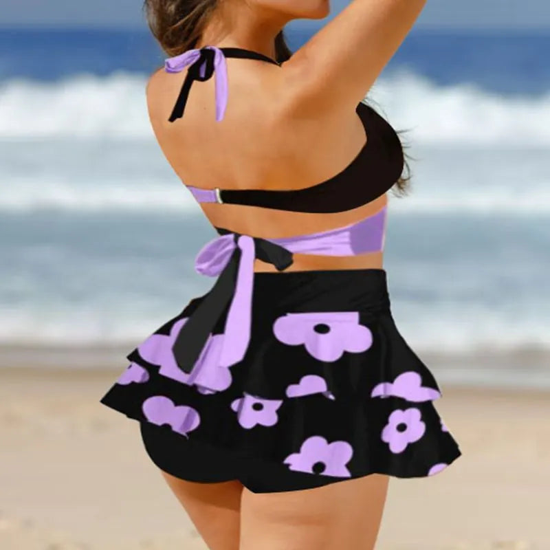 Women's purple bikini swimsuit with high-waisted briefs, backless design, lace-up top, and matching skirt for swimming.