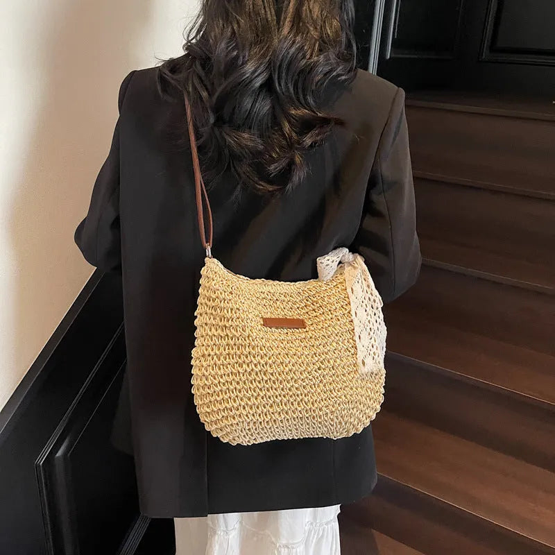 Women's woven straw messenger bag with hollowed design in khaki colour showing vertical square shape and single shoulder strap
