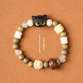 Hand-woven beaded bracelet with a cat's paw charm, multi-treasure cube, and mix of jade and wood beads.