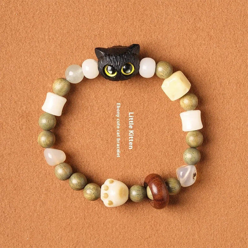 Hand-woven beaded bracelet with a cat's paw charm, multi-treasure cube, and mix of jade and wood beads.