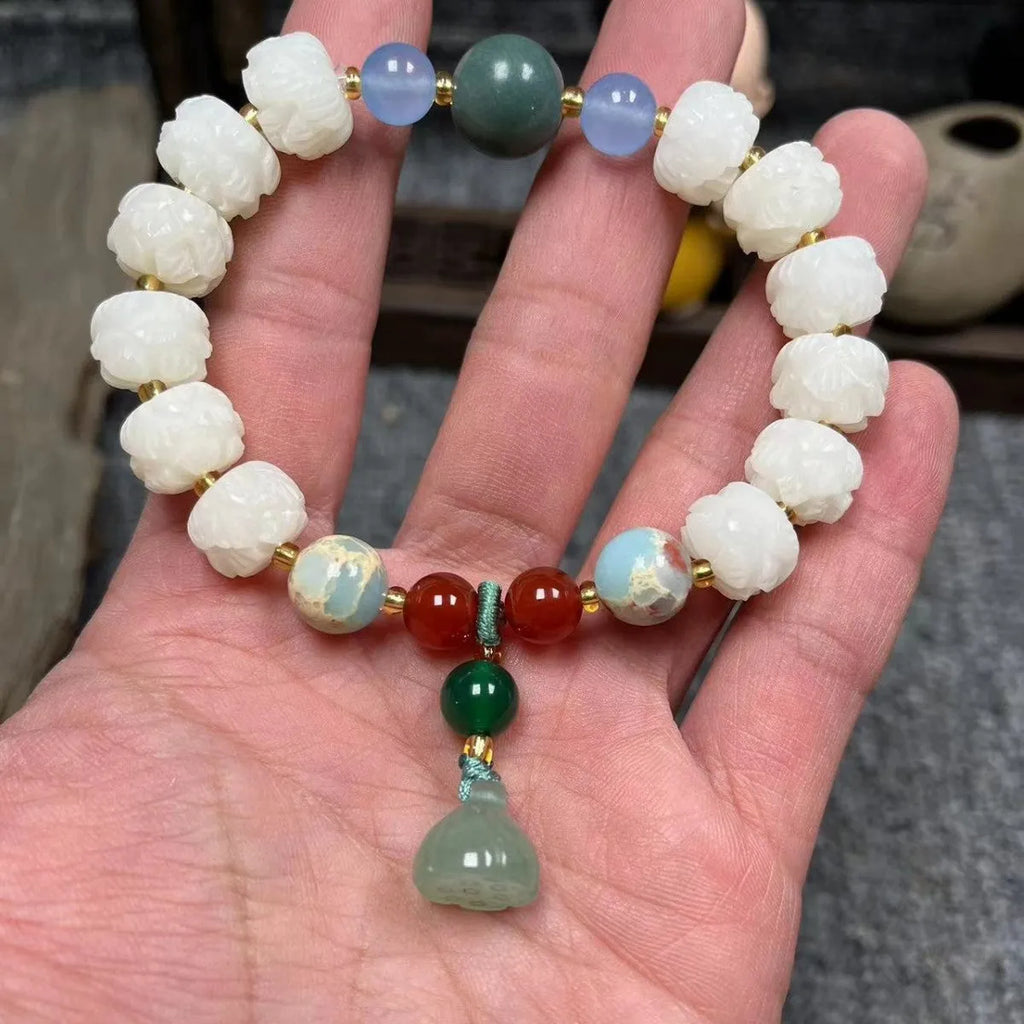 Hand-carved Bodhi root bracelet with White Jade beads, lotus carvings, and a cat's paw pendant.