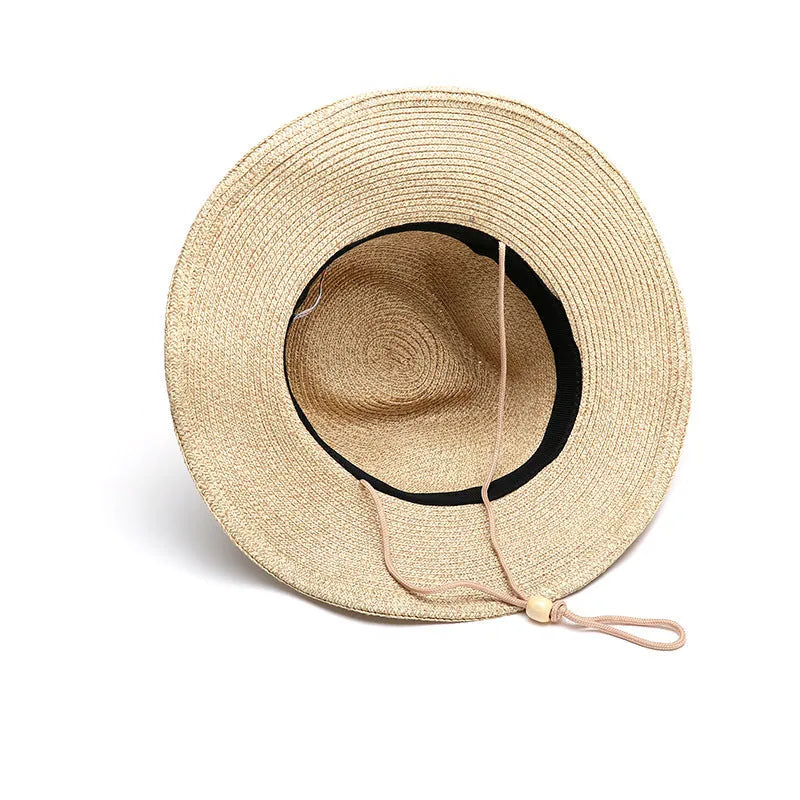 Men's foldable wide-brim straw sun hat in beige, showing its packable design.