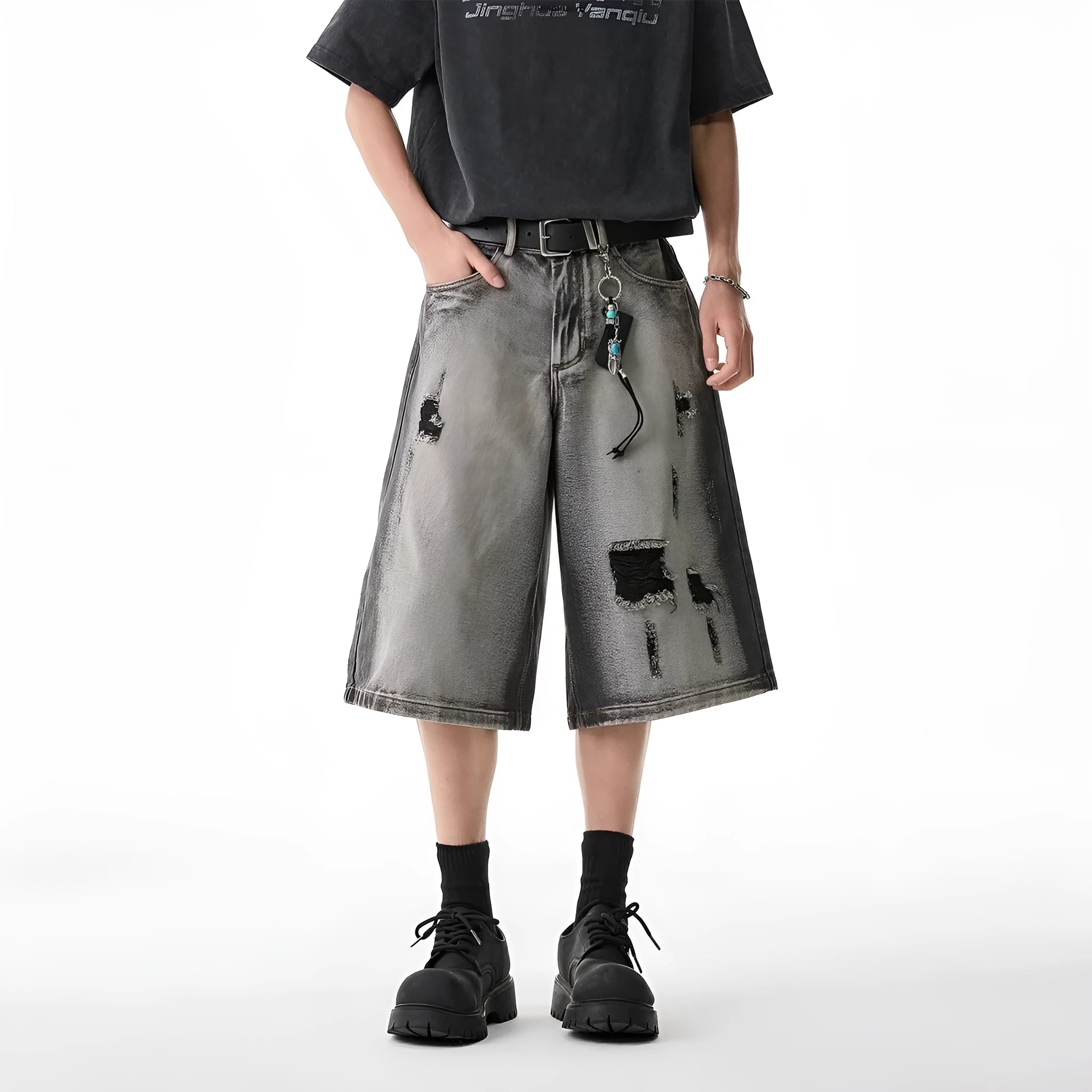 Grey denim shorts with washed finish and hole details, loose fit cropped length