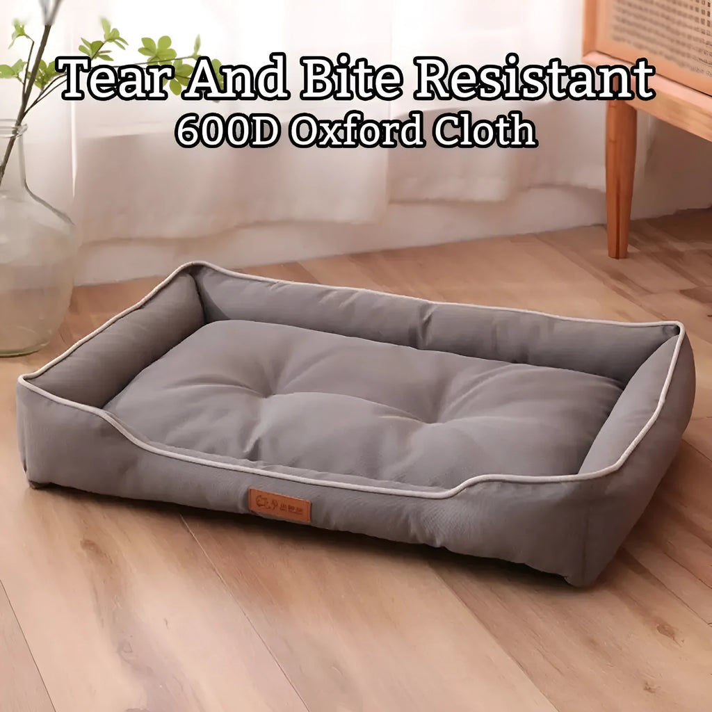 Grey raised cushion dog sofa bed with a waterproof Oxford cloth cover on a wooden floor.