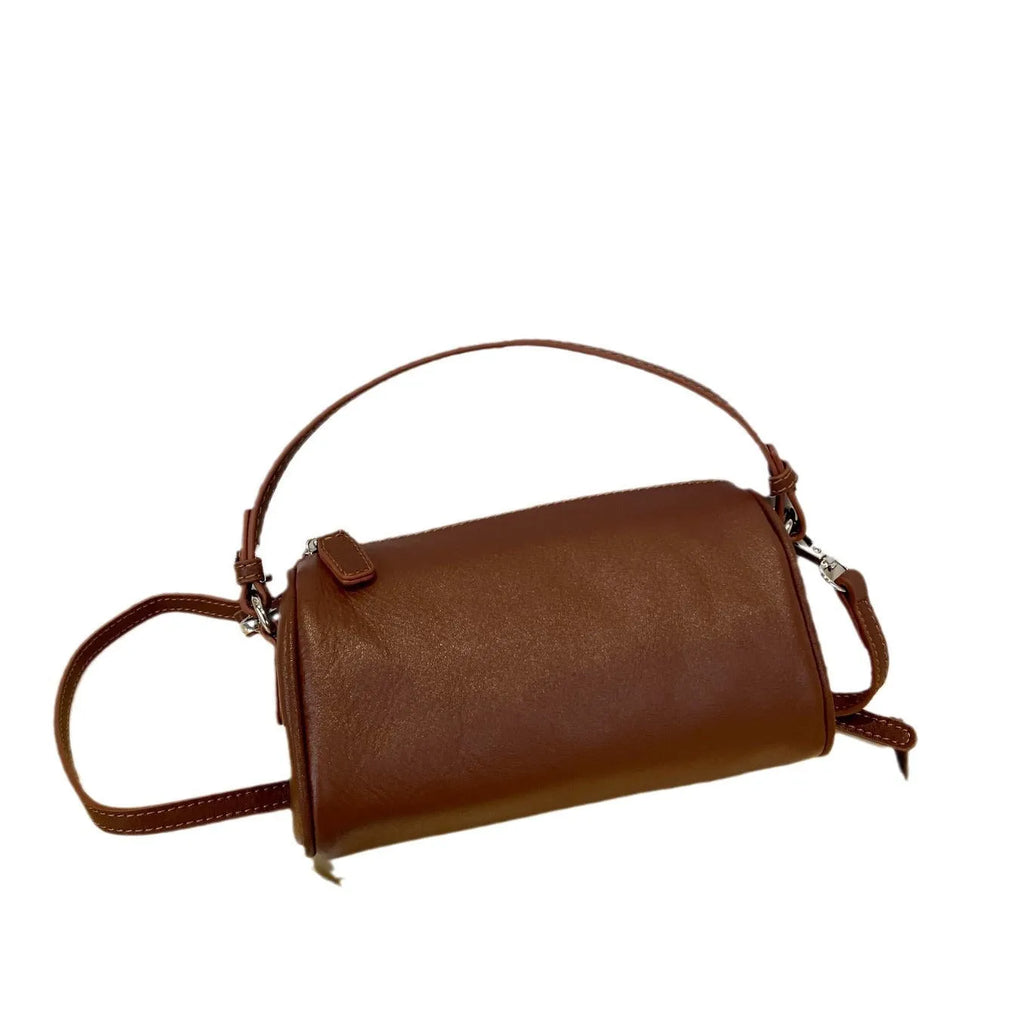 Cylindrical leather crossbody bag for mobile phones in six colours, showing visible sewing thread and compact size.
