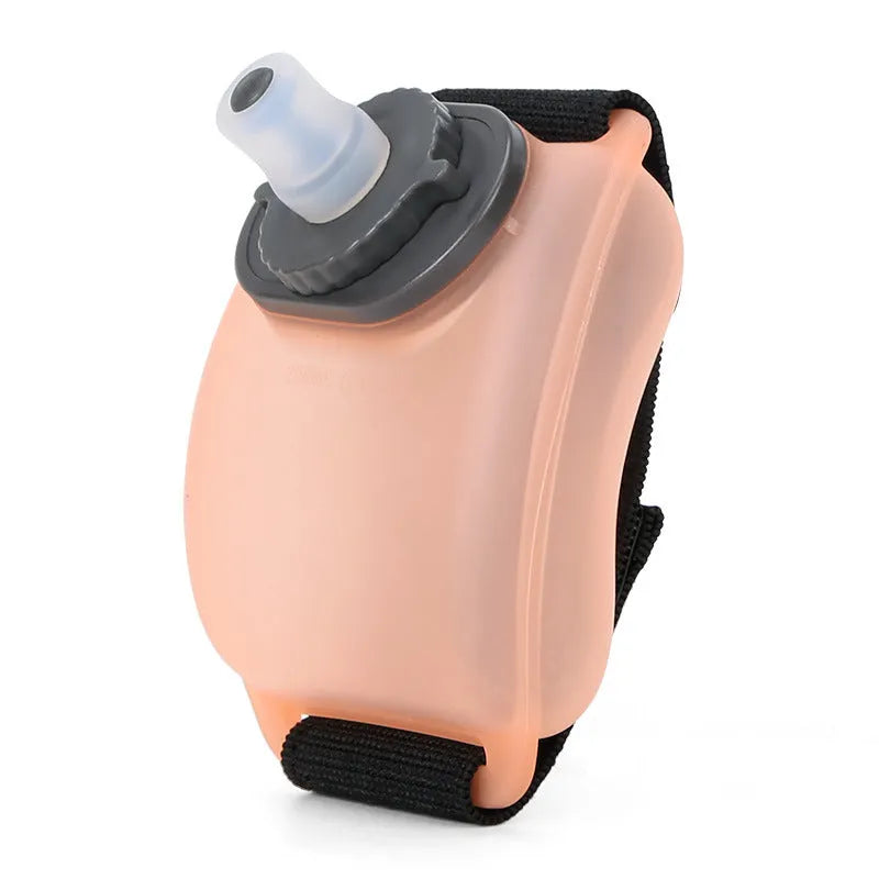 Orange silicone wrist water bottle with Velcro strap, shown worn on wrist for running.
