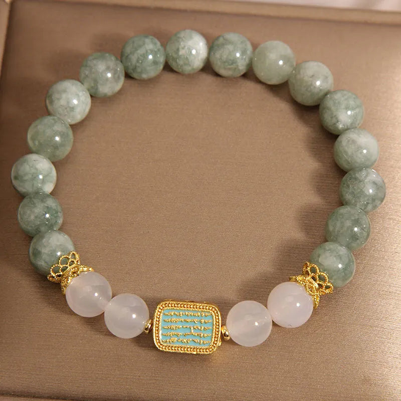 Natural oil green emerald crystal bracelet with five beads on a black elastic cord.