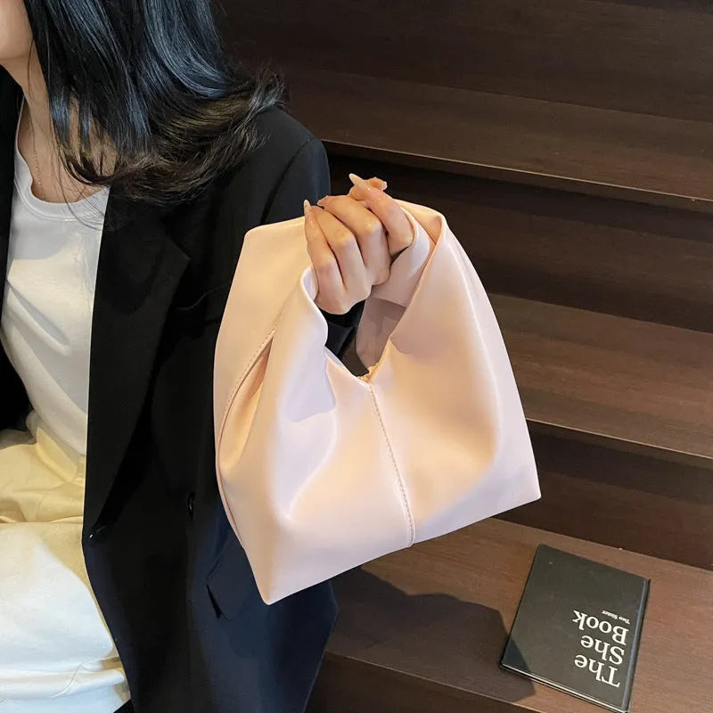 Dumpling-shaped women's handbag in various colours showing sandwich pocket design and fold-stitch details