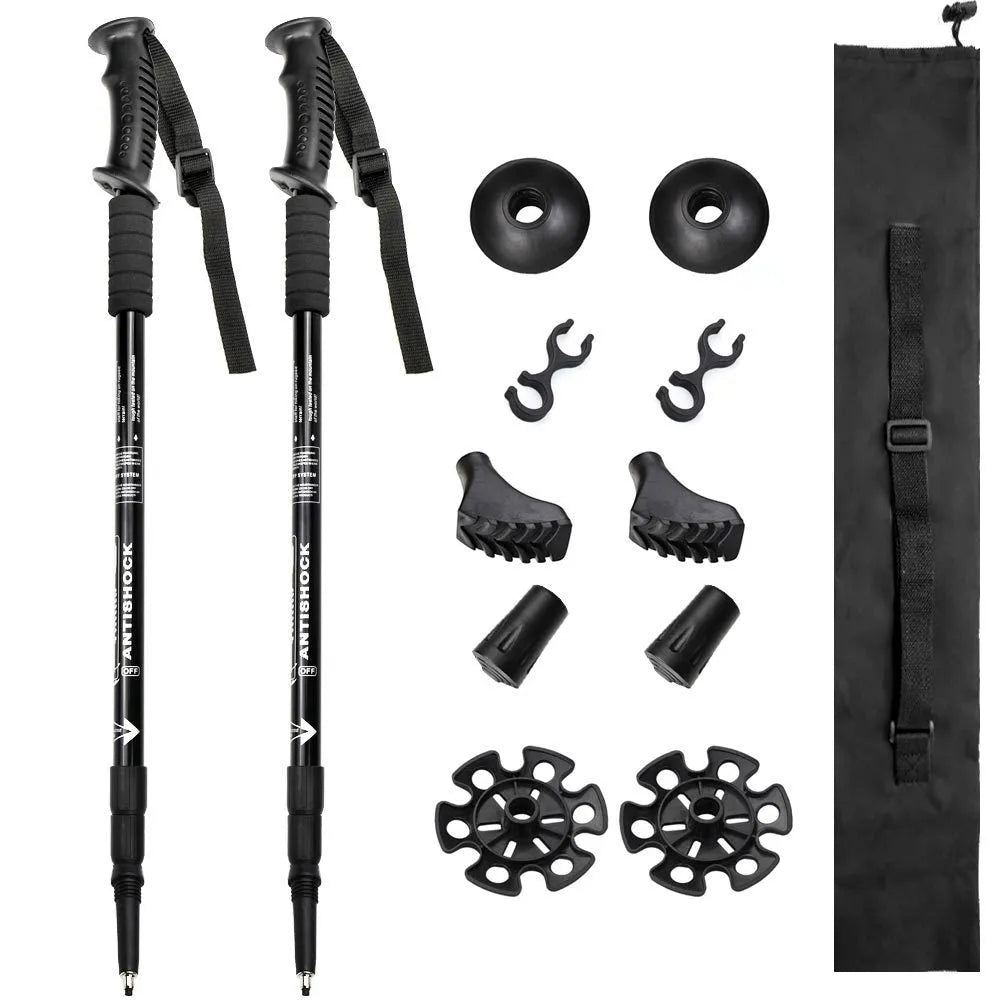 A pair of adjustable silver aluminium trekking poles with various foot attachments on a hiking trail.