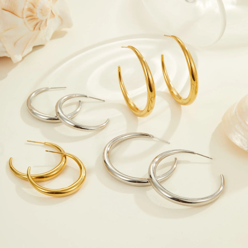 Gold and steel coloured titanium steel hoop earrings for women in large and small sizes.