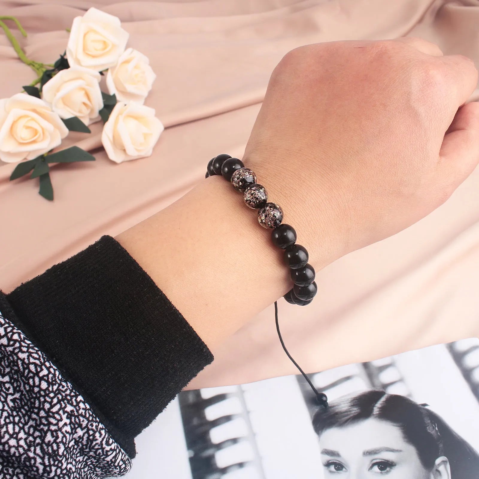 Geometric adjustable bracelet with luminous glass beads in sapphire blue on a wrist.