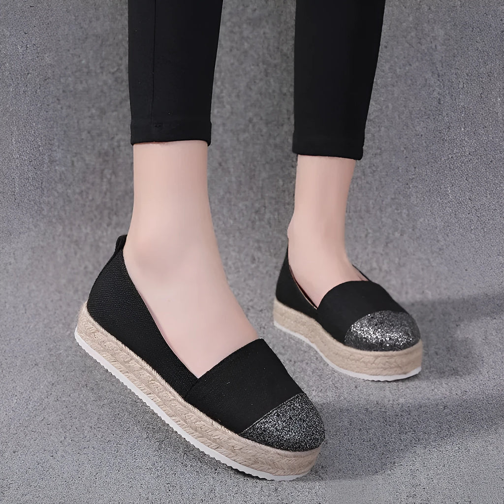 Beige and black canvas shoe covers with round toe design showing oversleeves construction