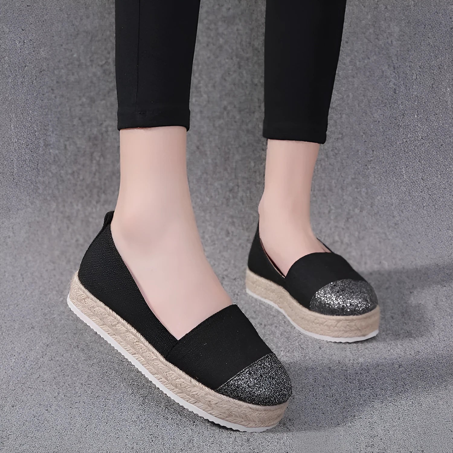 Beige and black canvas shoe covers with round toe design showing oversleeves construction