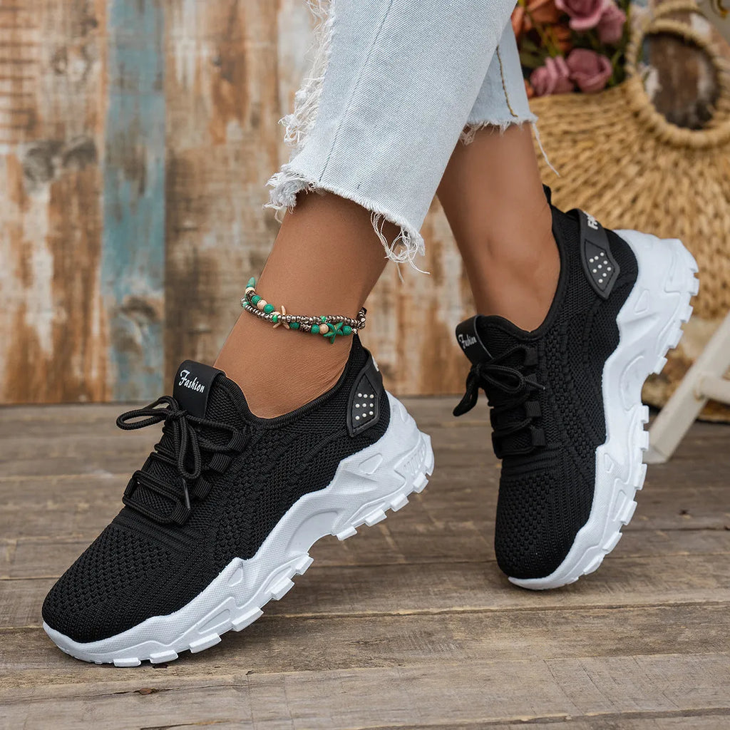 Women's white Flyknit mesh casual sports shoes with flat heel and lace-up front.