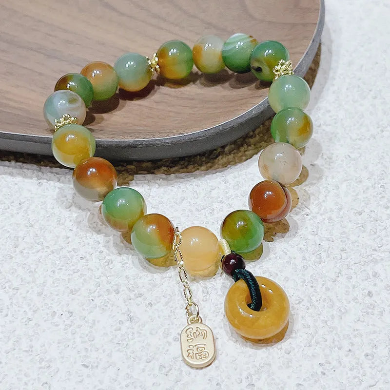 Yellow peacock agate and topaz bracelet with a peace buckle clasp and a lutong agate charm.