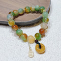 Yellow peacock agate and topaz bracelet with a peace buckle clasp and a lutong agate charm.