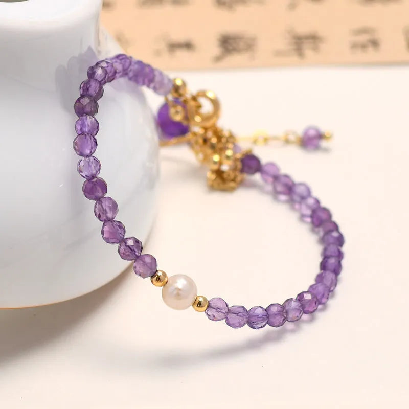 Amethyst crystal bracelet with diamond-shaped stones, adjustable chain, and Chinese-style clasp on wrist