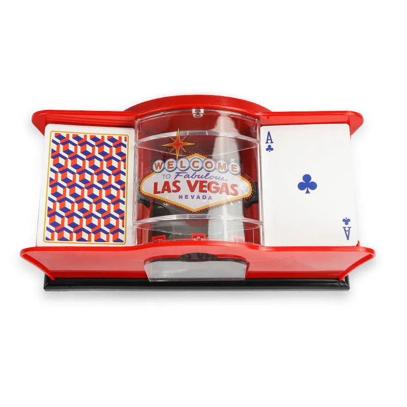 Black manual card shuffler with hand crank on a table next to playing cards.