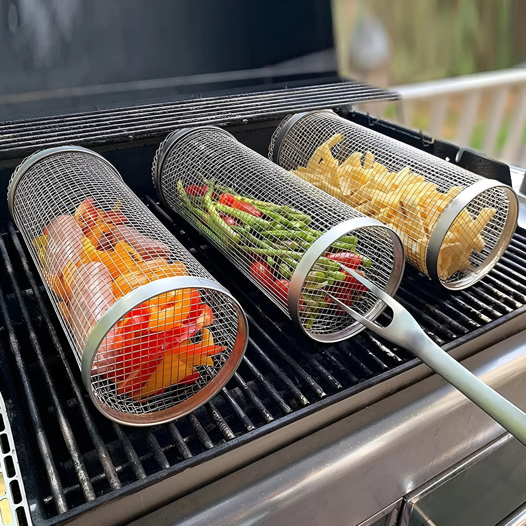 Stainless steel cylindrical rolling grill basket for BBQ with wire mesh, shown with vegetables inside.