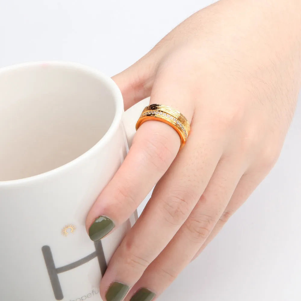 Gold geometric women's ring with zircon stone, showing clean lines and symmetrical design on hand