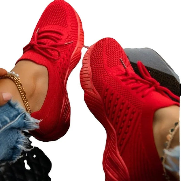 Women's white thick-sole dad sneakers on a plain background, showing the chunky sports shoe design.