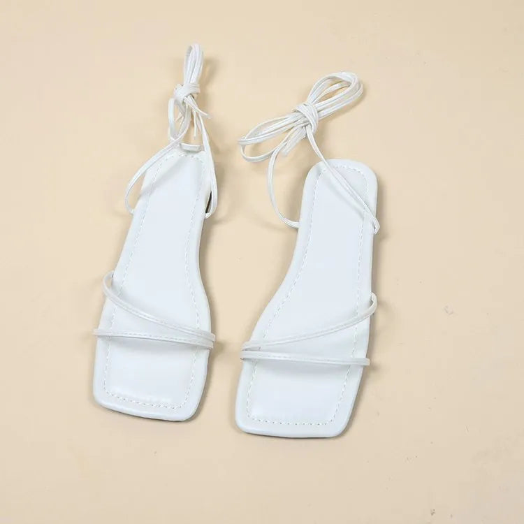 Women's flat sandals with ankle ring bandage cloth design in black colour showing square toe and rubber soles
