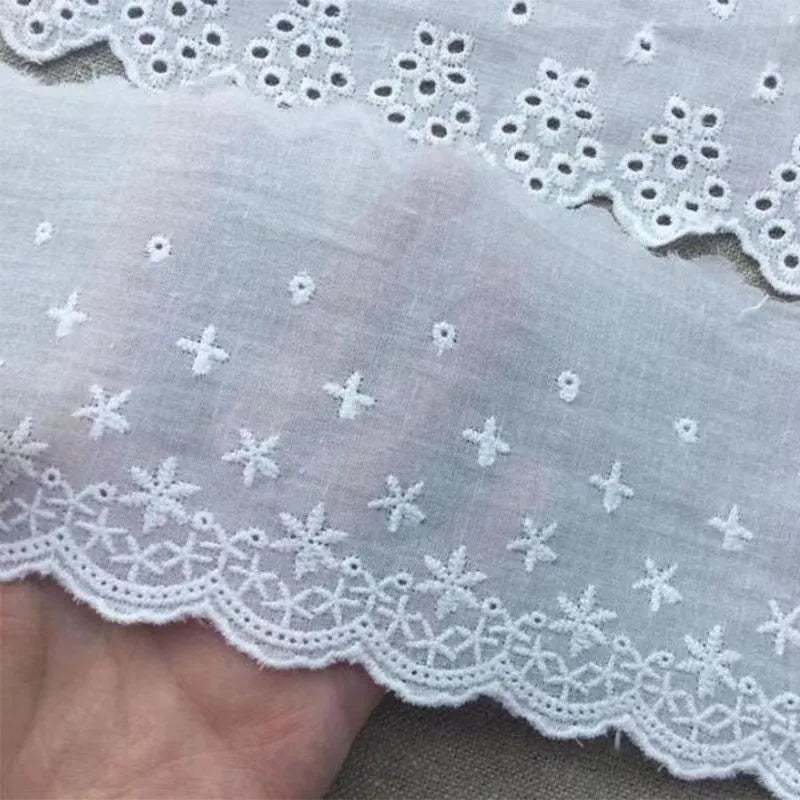 Reel of white embroidered cotton lace trim with a cutout design, showing four different width styles for DIY sewing.
