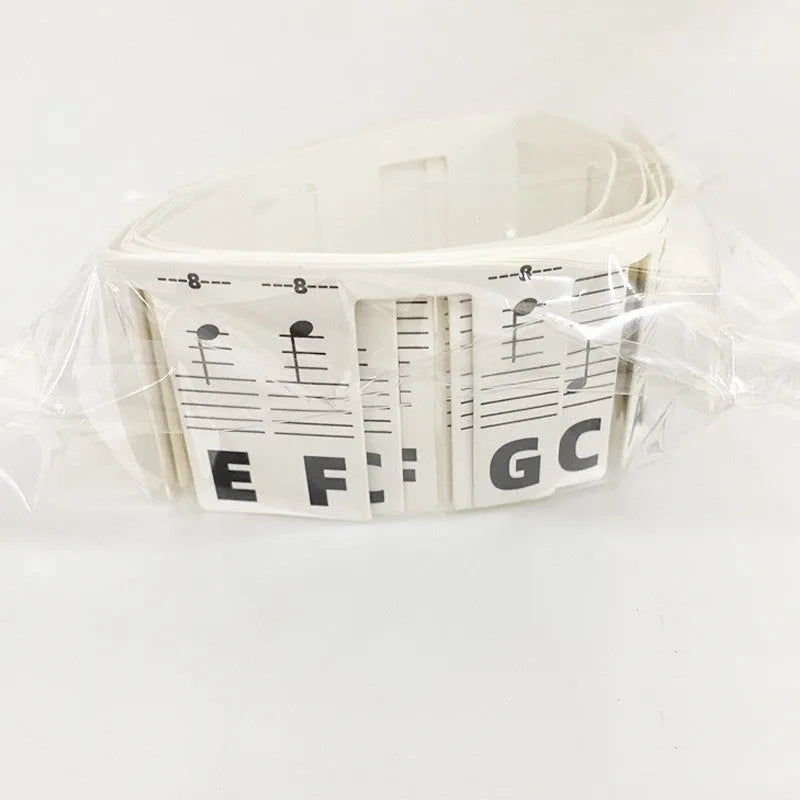 Set of 88 white cardboard piano key stickers showing staff notation and colour note bars for a full-size keyboard.